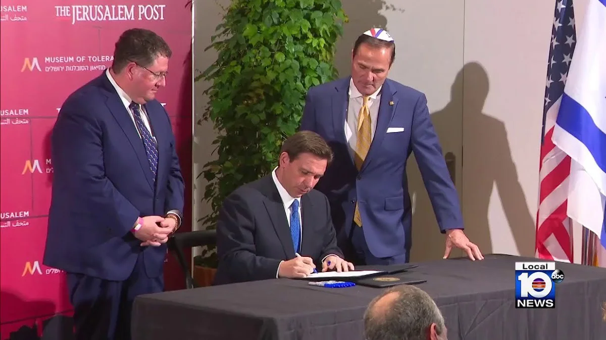 The man standing next to Ron DeSantis in Isreal is Mike Caruso, currently on trial for forcing his ...